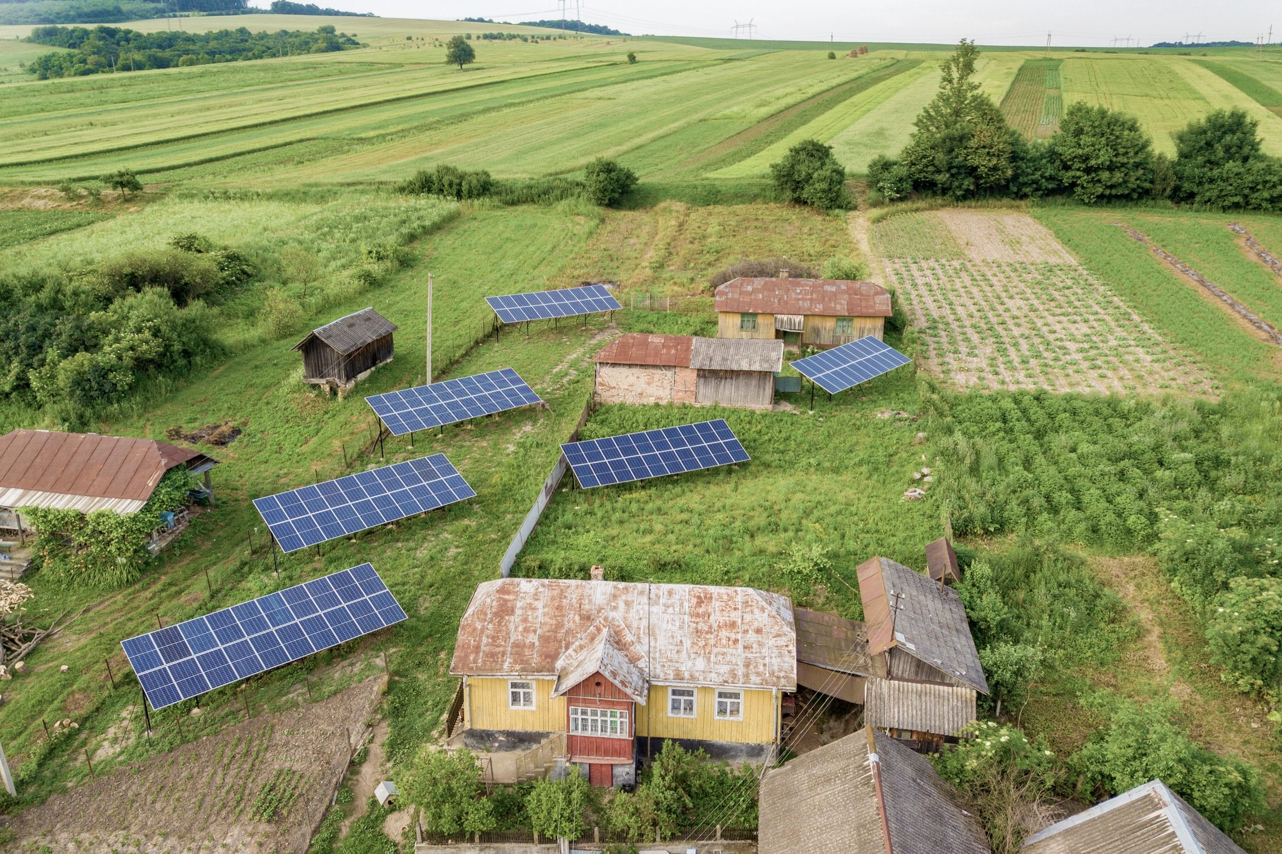 Obere Ansicht von Solarmodulen inmitten einer grünen Landschaft