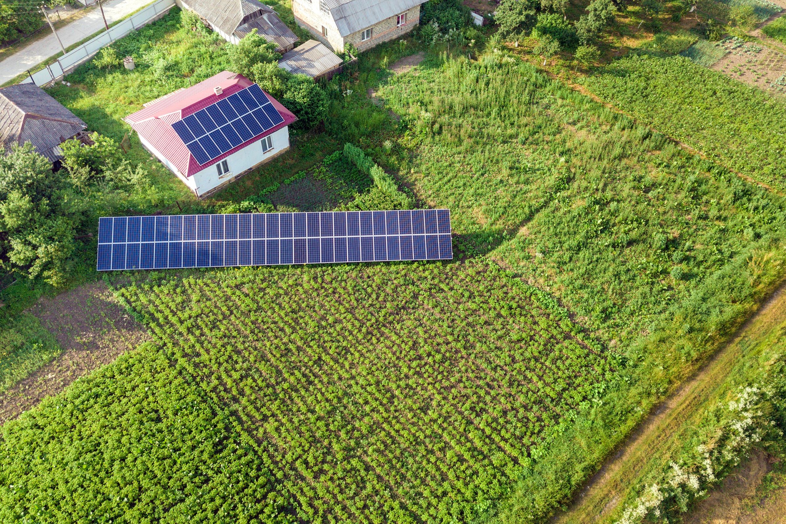 Haus mit blauen Solarmodulen auf dem Dach, aufgenommen aus der Luft