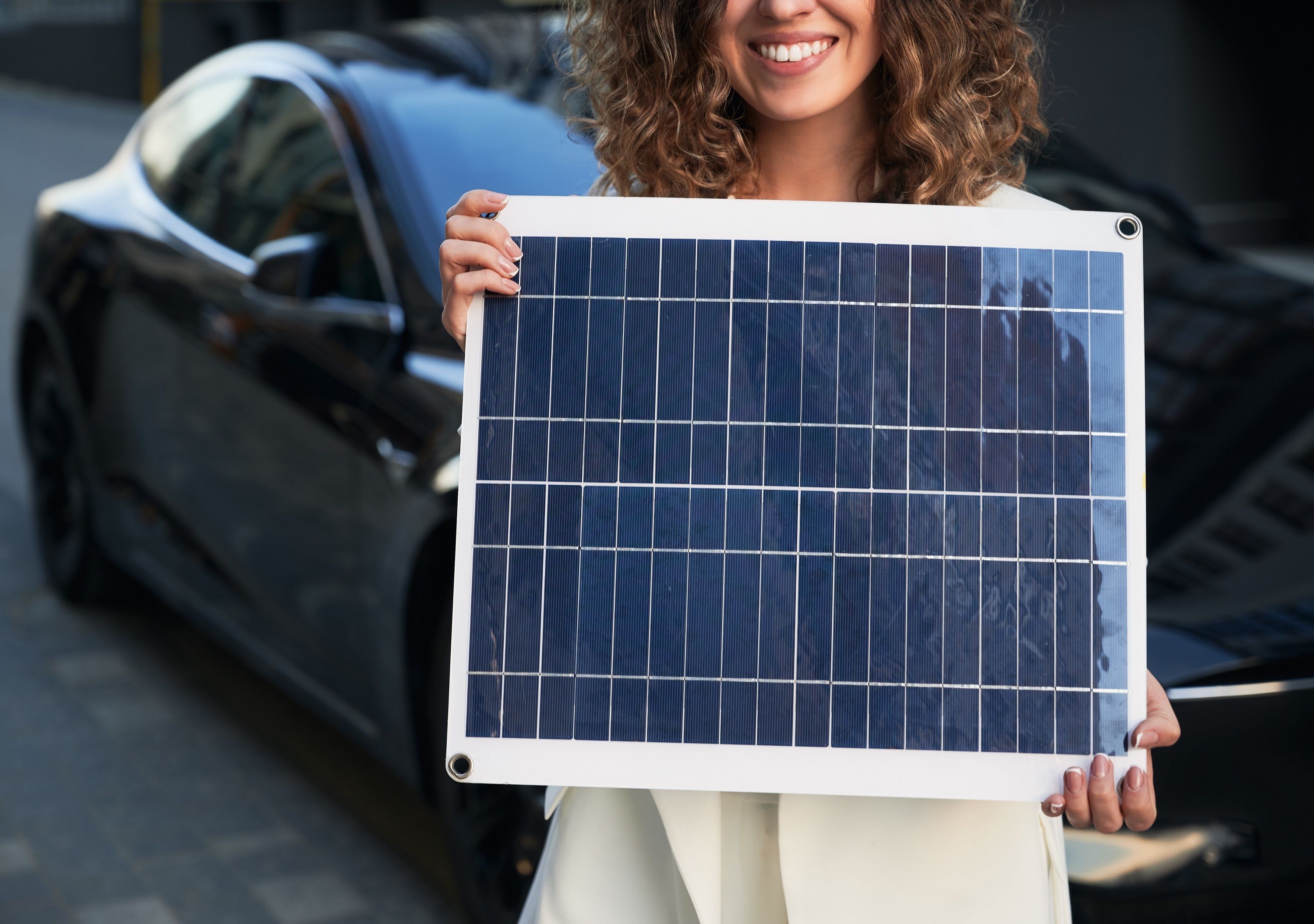 Frau hebt Photovoltaik-Modul