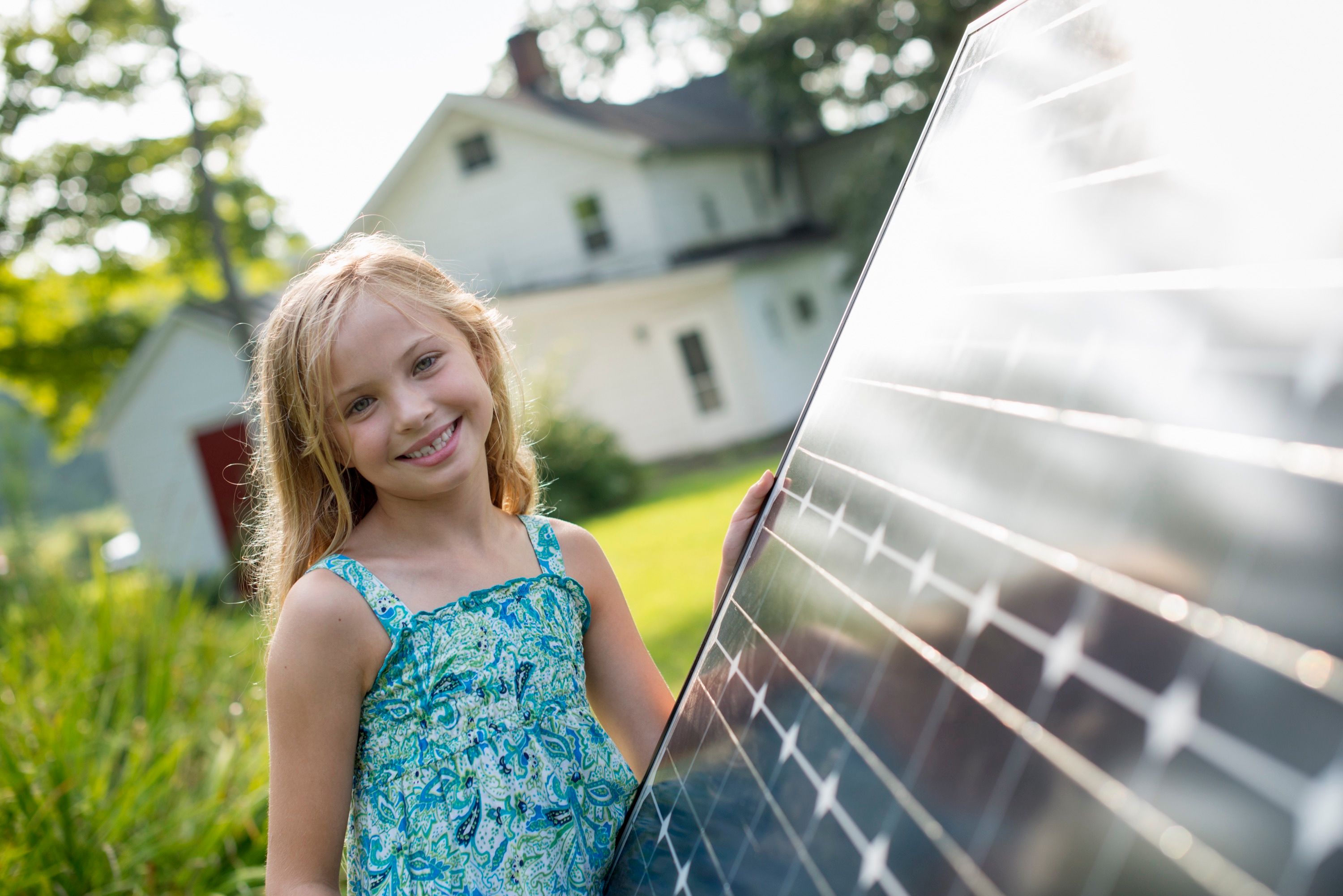 Junges Mädchen steht vor Photovoltaik