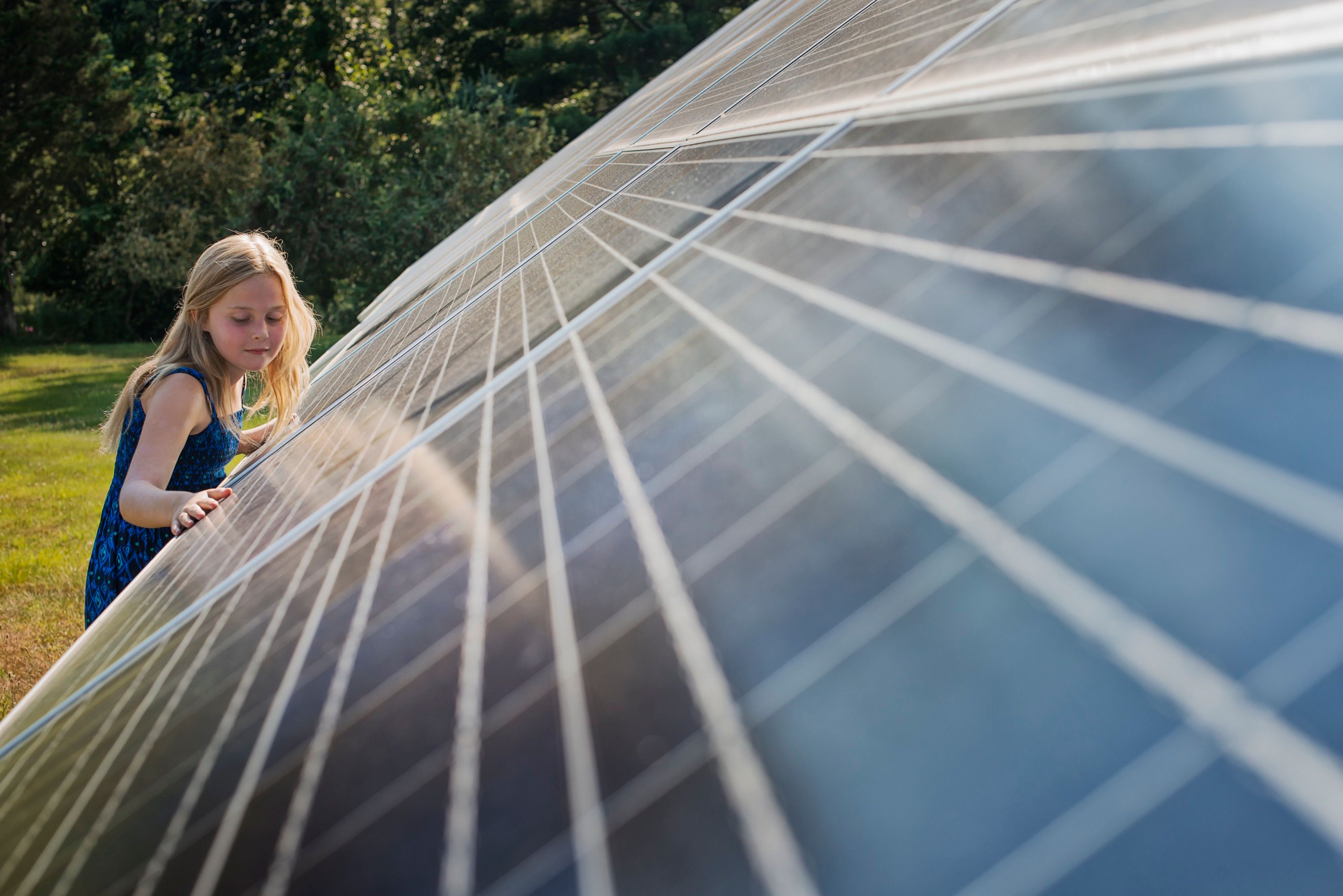 Mädchen steht hinter Photovoltaik